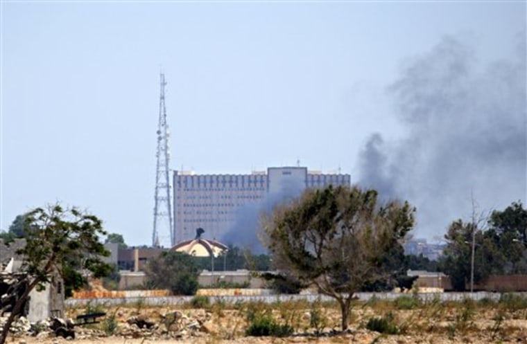 Smoke rises over buildings in Muammar Gadhafi's main compound in the Bab al-Aziziya district of Tripoli, Libya, Tuesday, Aug. 23, 2011. Fresh fighting erupted in Tripoli on Tuesday hours after Moammar Gadhafi's son turned up free to thwart Libyan rebel claims he had been captured, a move that seems to have energized forces still loyal to the embattled regime. (AP Photo/Sergey Ponomarev)